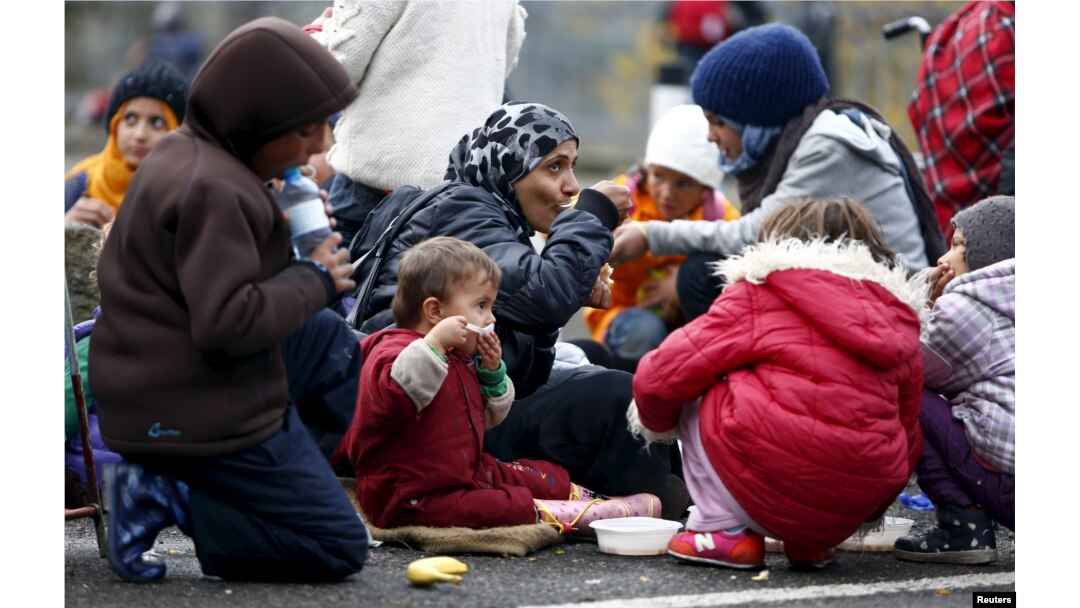 FILE - Migrants rest before crossing the Austrian-German border in Achleiten, Austria, across from Passau, Germany, Oct. 29, 2015.