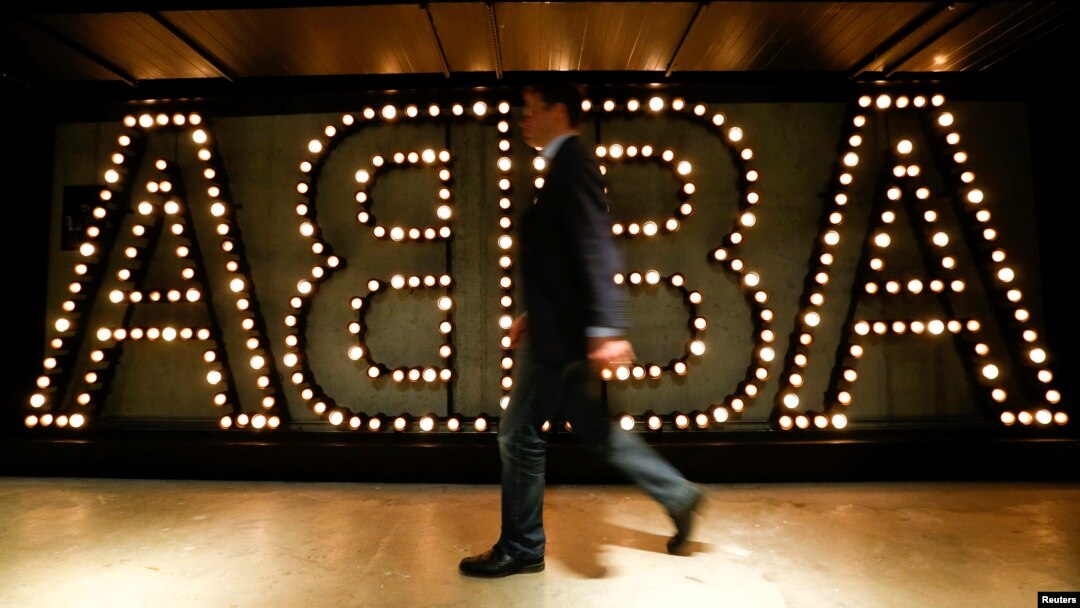 A man walks past the lit logo of the legendary Swedish pop group ABBA at the new "ABBA - The Museum" in Stockholm, May 6, 2013. 