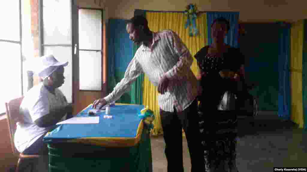 A voter looks at the paper ballot before choosing his candidate in Kigali, Aug. 4, 2017. (Pnoto: Charly Kasereka / VOA)