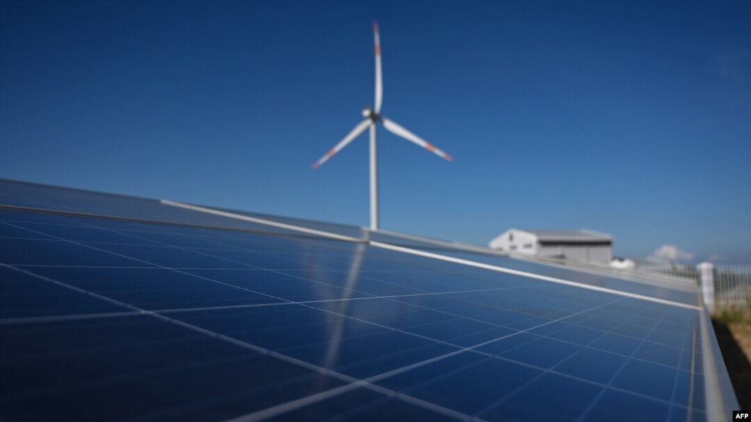 FILE - A solar panel installation is seen near a wind turbine at the Phu Lac wind farm in southern Vietnam's Binh Thuan province, April 23, 2019. 