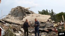 Watu wakitizama eneo la shambulizi la anga la Israel lililolenga nyumba moja katika kijiji cha Jibshit kusini mwa Lebanon, Februari 27, 2024. Picha ya AFP