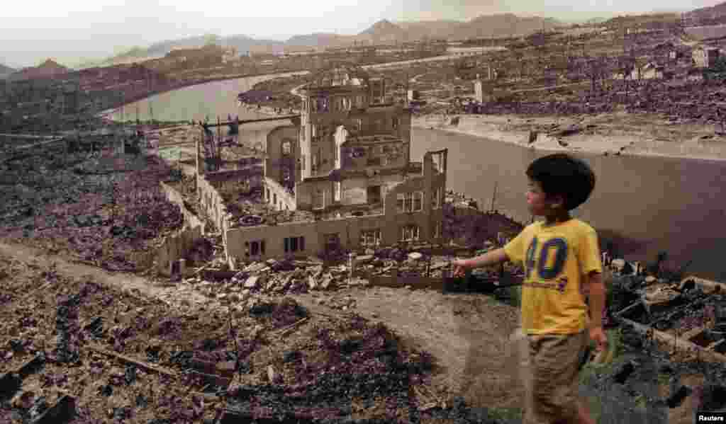 A boy looks at a huge photograph showing Hiroshima city after the 1945 atomic bombing, at the Hiroshima Peace Memorial Museum, Japan, August 6, 2007.