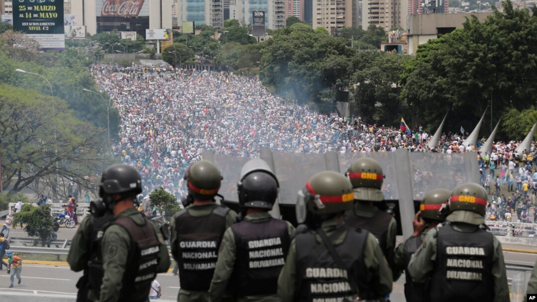 FILE - Bolivarian National Guards stand on a highway overlooking an anti-government march trying to make its way to the National Assembly in Caracas, Venezuela, May 3, 2017.