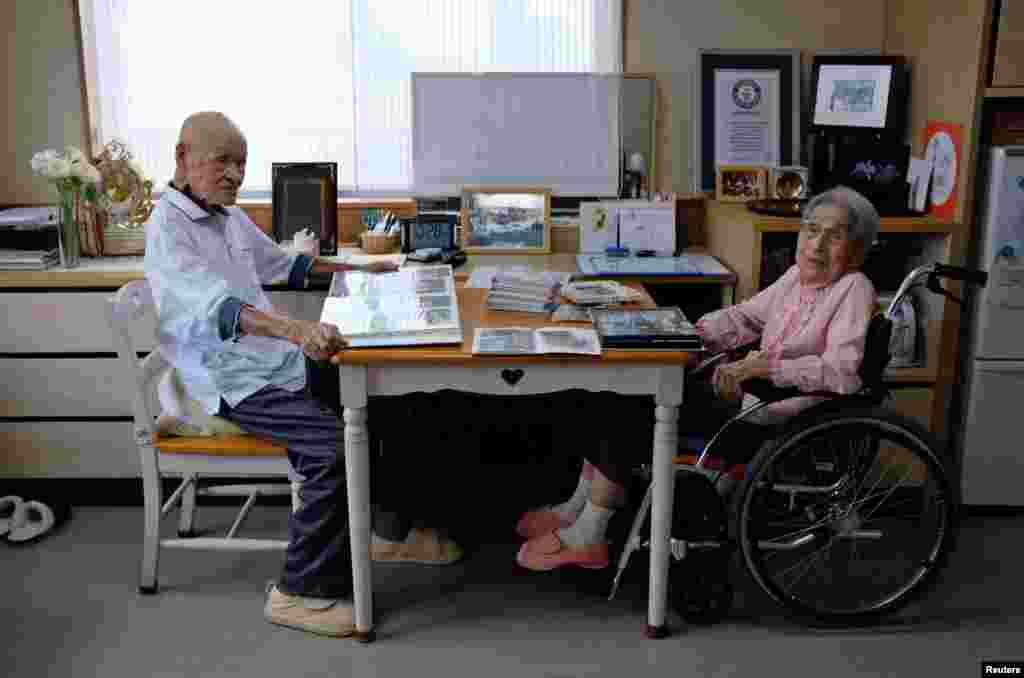 World's oldest living married couple Masao Matsumoto (L) and Miyako Matsumoto look at albums in their room at a nursing house in Takamatsu, Kagawa prefecture, Japan.