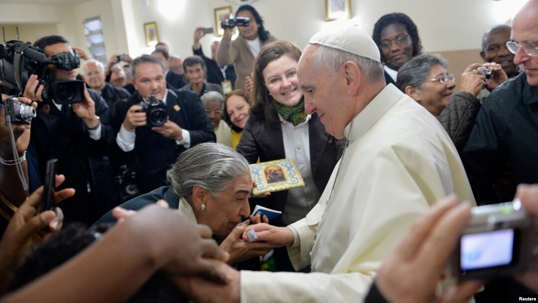 Pope Francis greets residents of Varginha slum inside the local church, in Rio de Janeiro, Brazil, July 25, 2013.