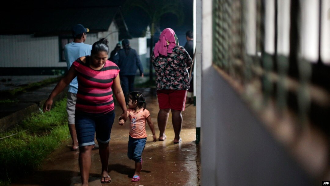 Una mujer y su hija caminan en un refugio temporal antes de la llegada de la tormenta tropical Bonnie en Bluefields, Nicaragua, el 1 de julio de 2022. (Foto de OSWALDO RIVAS / AFP)