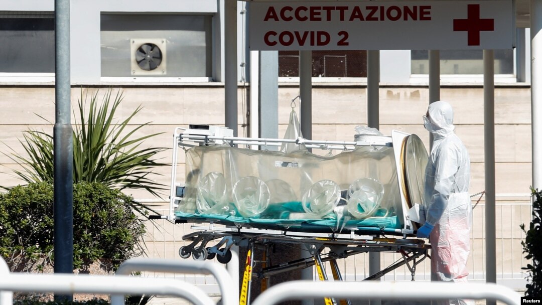 A medical worker in a protective suit stands with an isolation stretcher in front of the Columbus Clinic, where patients suffering from coronavirus disease (COVID-19) were moved from Spallanzani Hospital, in Rome, Italy, March 16, 2020. 