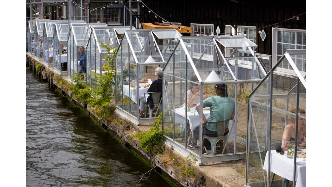 FILE - Customers eat lunch in small glass houses at the Mediamatic restaurant in Amsterdam, Netherlands, June 1, 2020.
