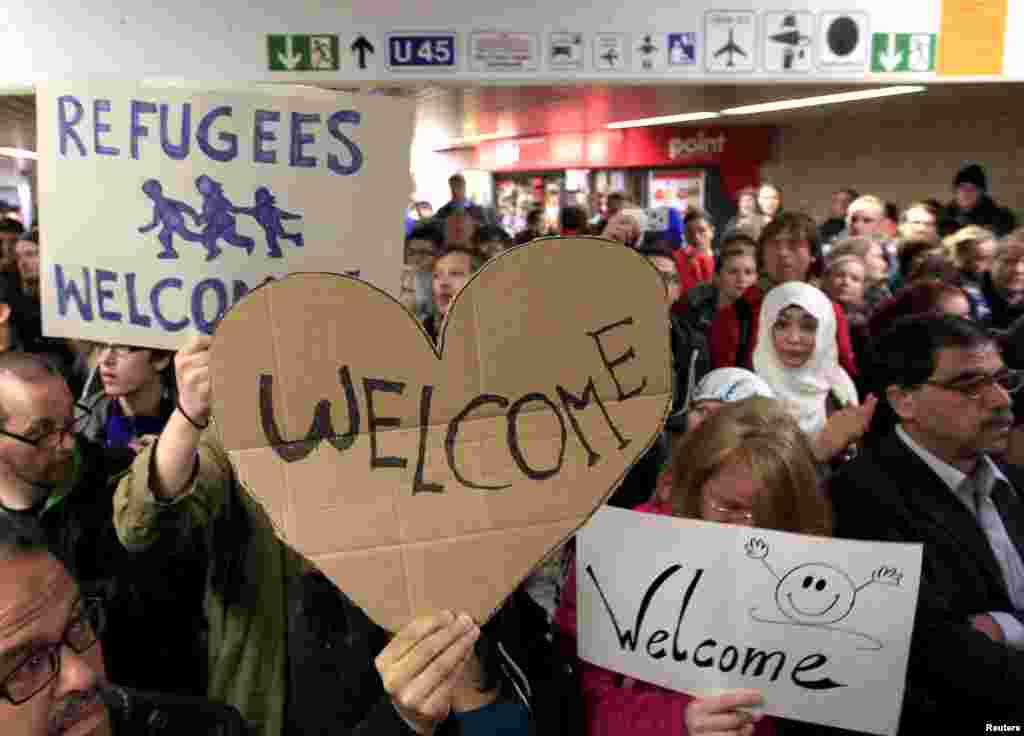 Wellwishers wave to migrants arriving at the main railway station in Dortmund, Germany, Sept. 6, 2015. Austria and Germany opened their borders to thousands of exhausted migrants, bussed to the Hungarian border by a right-wing government that had tried to stop them but was overwhelmed by the sheer numbers reaching Europe&#39;s frontiers.