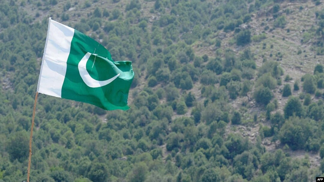 FILE - A Pakistani flag flies at Manatu mountain in the central part of Kurram Agency, Pakistan's tribal belt bordering Afghanistan, July 10, 2011. 