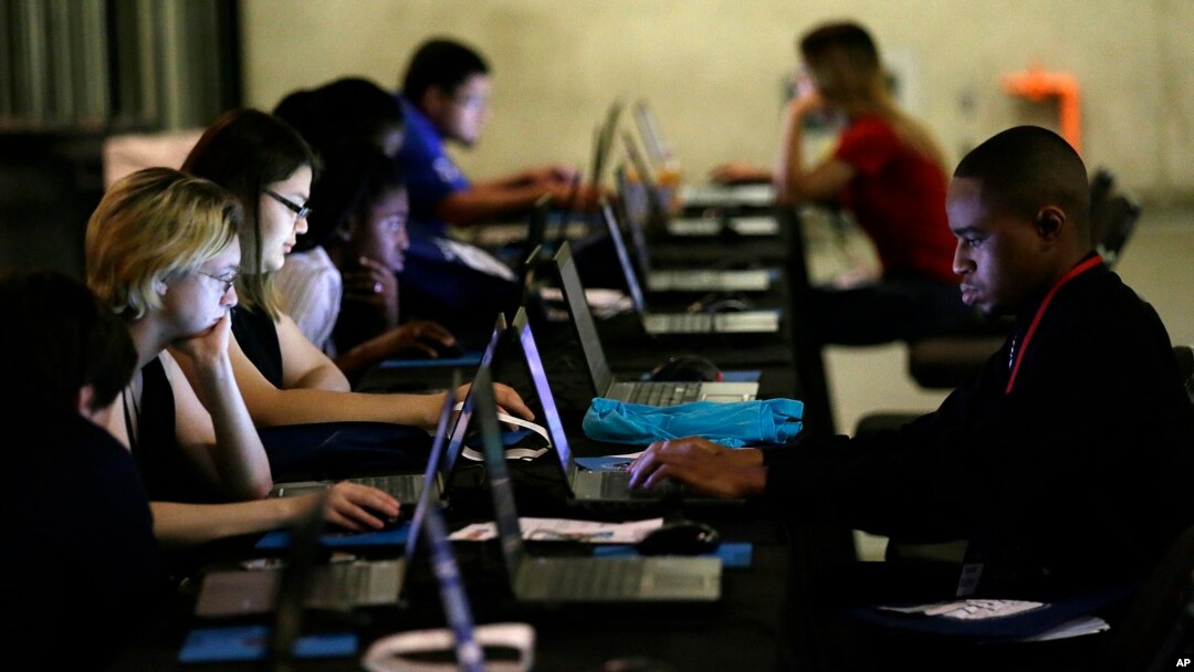 FILE - In this May 19, 2017, photo, job seekers work on their resumes during the Opportunity Fair and Forum employment event in Dallas. 