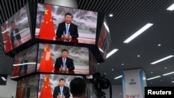 上海举行的中国国际进出口展销会媒体中心的多面电视屏幕正在播放中国领导人习近平的讲话。（2021年11月4日）