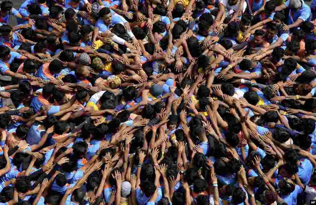 Indians form a human pyramid to break the "Dahi Handi," an earthen pot filled with curd hanging above them, as part of celebrations to mark the Janmashtami festival in Mumbai.