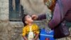 A boy receives polio vaccine drops, during an anti-polio campaign, in a low-income neighborhood in Karachi, Pakistan, April 9, 2018. 