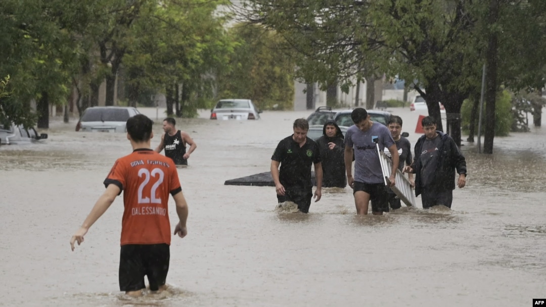 Personas caminan por una calle inundada después de que una poderosa tormenta azotara la ciudad de Bahía Blanca, a 600 kilómetros al sur de la capital de Argentina, el 7 de marzo de 2025.