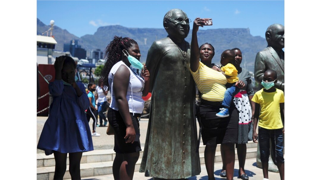 People take photos at a statue of Anglican Archbishop Desmond Tutu at the V&A Waterfront in Cape Town, South Africa, Sunday, Dec. 26, 2021.(AP)