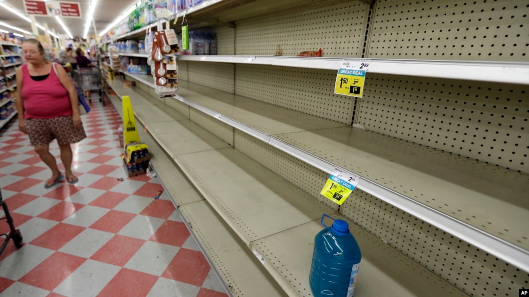 Shoppers pass empty shelves along the bottled water aisle in a Houston grocery store as Hurricane Harvey intensifies in the Gulf of Mexico, Aug. 24, 2017.