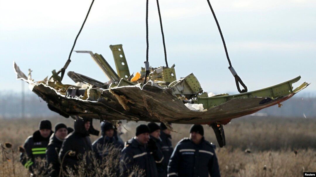 FILE - A crane transports a piece of the Malaysia Airlines Flight MH17 wreckage at the crash site in eastern Ukraine's Donetsk region, Nov. 20, 2014.