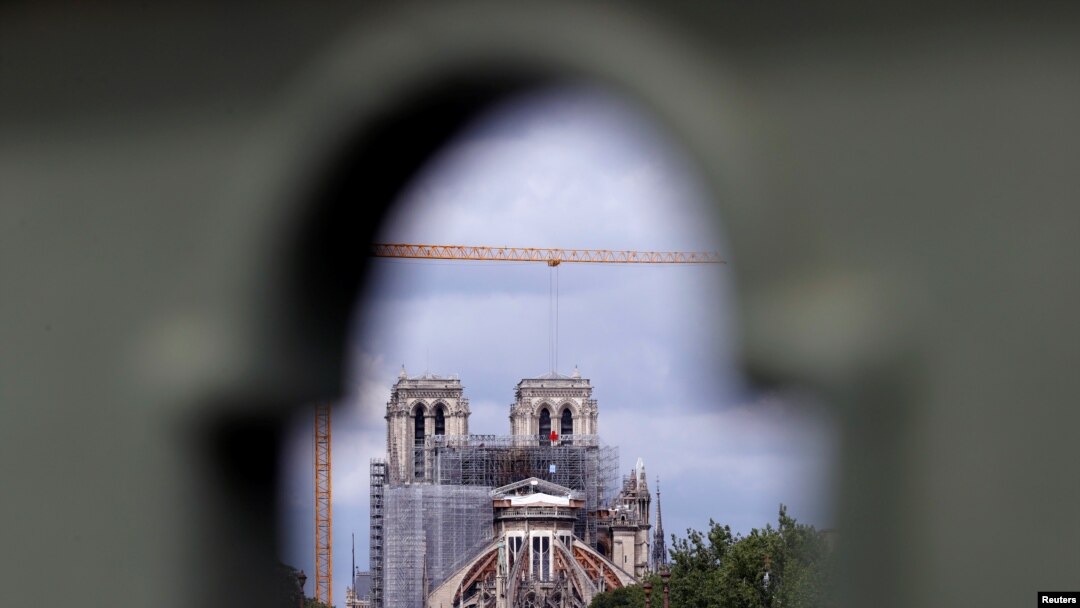 A view shows Notre Dame Cathedral, as workers prepare to remove damaged scaffolding elements from the remains of the burnt roof, in Paris, June 8, 2020. 