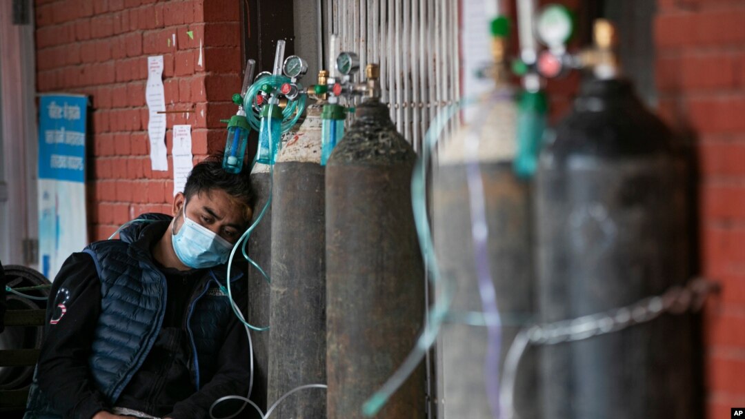 FILE - A COVID-19 patient receives oxygen outside an emergency ward at a government-run hospital in Kathmandu, Nepal, May 13, 2021. 