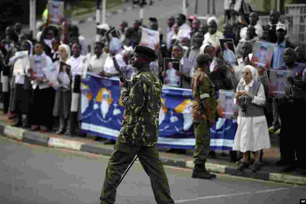 Soldiers patrol as people wait for the arrival of Pope Francis, in Nairobi's State House, Nov. 25, 2015.