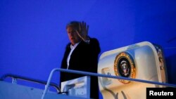 El presidente de Estados Unidos, Donald Trump, saluda cuando llega a bordo del Air Force One después de regresar de un viaje de dos días a la India, en la Base Conjunta Andrews en Maryland, EE. UU.