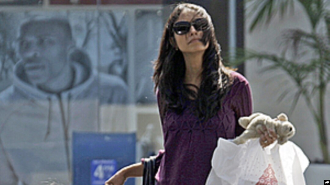 A woman and child leave a mall with purchases in Culver City, Calif., (File).