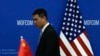 2023年8月28日，商务部长吉娜·雷蒙多(Gina Raimondo)和中国商务部部长王文涛在北京商务部会晤前，一名中国官员走过中美两国国旗。