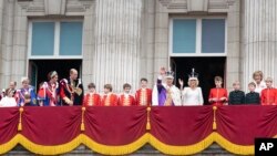 El rey Carlos III y la reina Camila aparecen en el balcón del Palacio de Buckingham, Londres, con miembros de la familia real, después de la ceremonia de coronación, el sábado 6 de mayo de 2023. (Stefan Rousseau/vía AP)