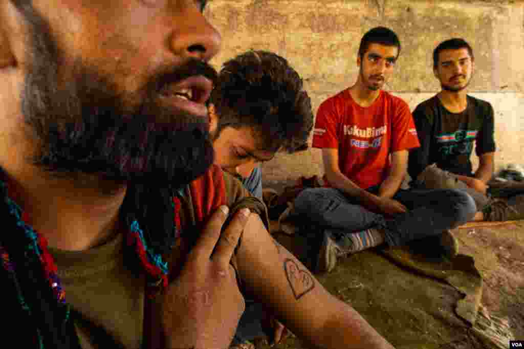 This man shows a tattoo of his fiancee's initials, saying he hopes to one day go back to Afghanistan to collect her, Aug. 31, 2021, in eastern Turkey.