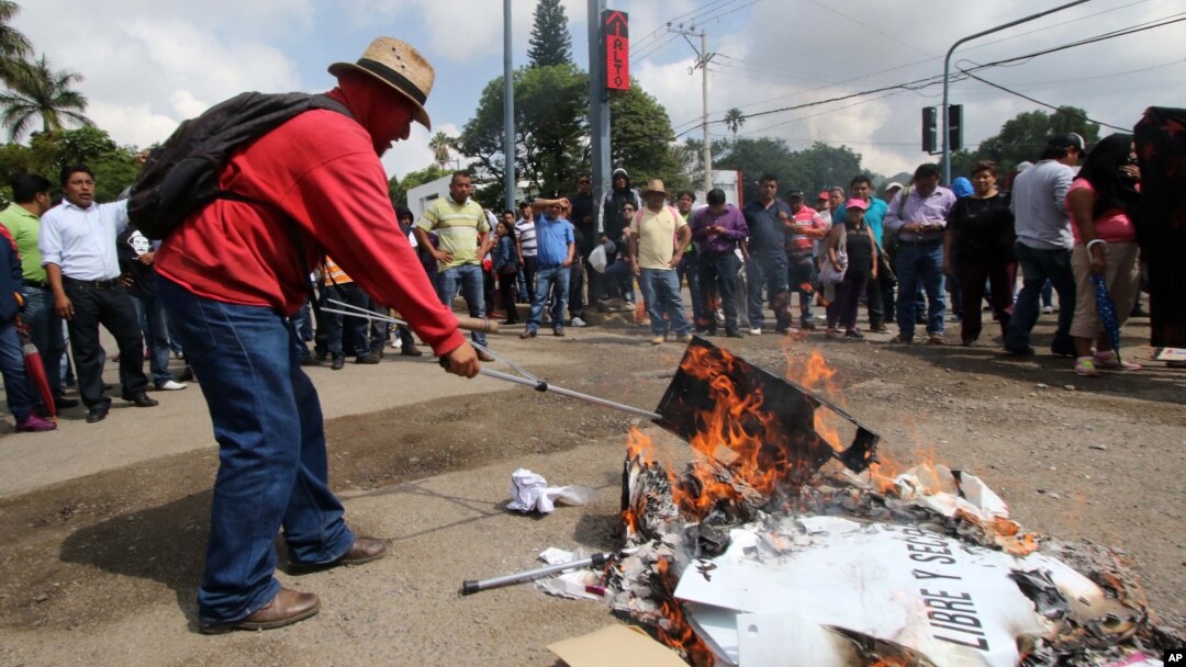Protesters burn ballot boxes and ballots in the city of Oaxaca, Mexico, June 7, 2015.