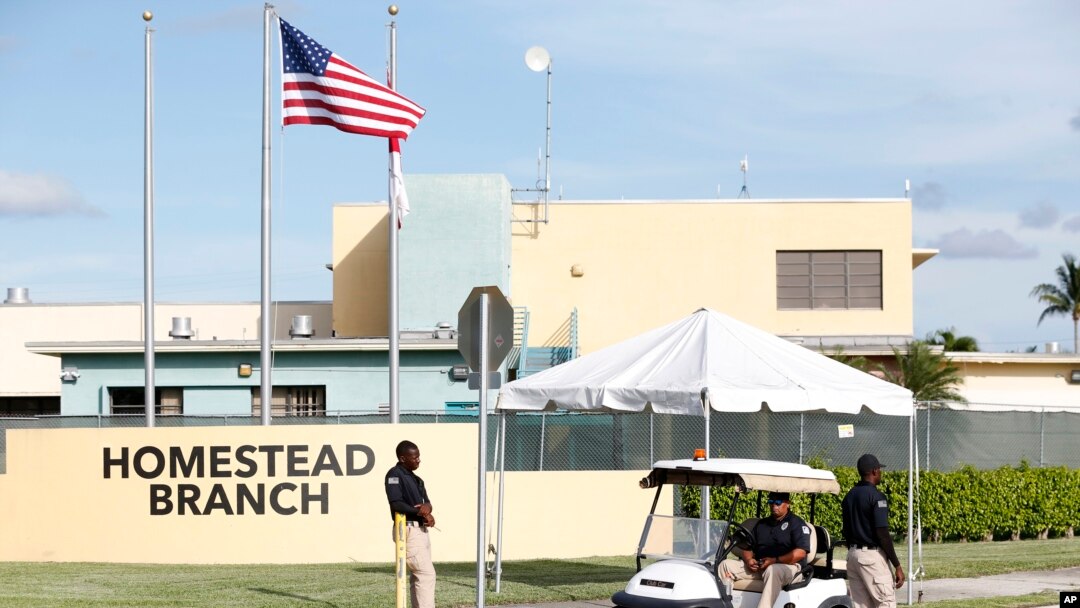 Security guards stand outside a former Job Corps site that now houses child immigrants, June 18, 2018, in Homestead, Fla. It is not known if the children crossed the border as unaccompanied minors or were separated from family members.