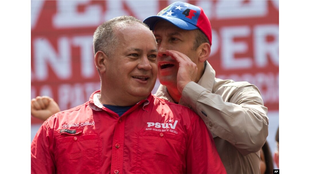 Government politician Diosdado Cabello listens to Venezuela's Vice President Tareck El Aissami at a rally opposing the United States and possible OAS sanctions, in Caracas, Venezuela, March 28, 2017.