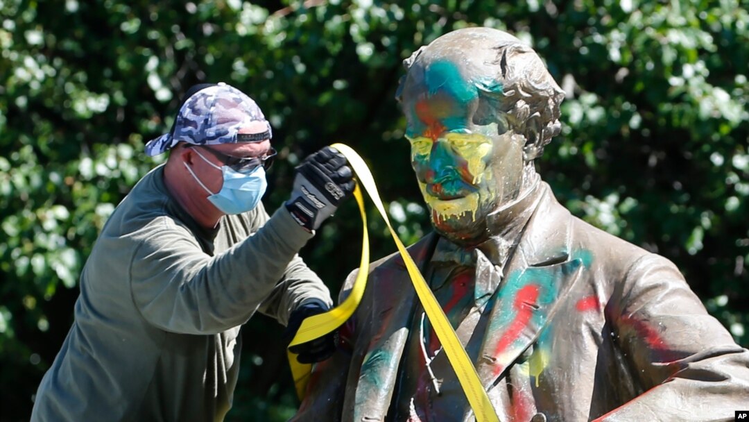 A worker secures the statue of Confederate Naval officer Matthew Fontaine Maury to a truck on Monument Avenue, in Richmond, Va., July 2, 2020.