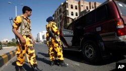 Houthi Shiite Yemenis wearing police uniforms check a vehicle at a street ahead of a tribal meeting held by Houthi Shiite rebels in Sanaa, Yemen, Oct. 31, 2014.