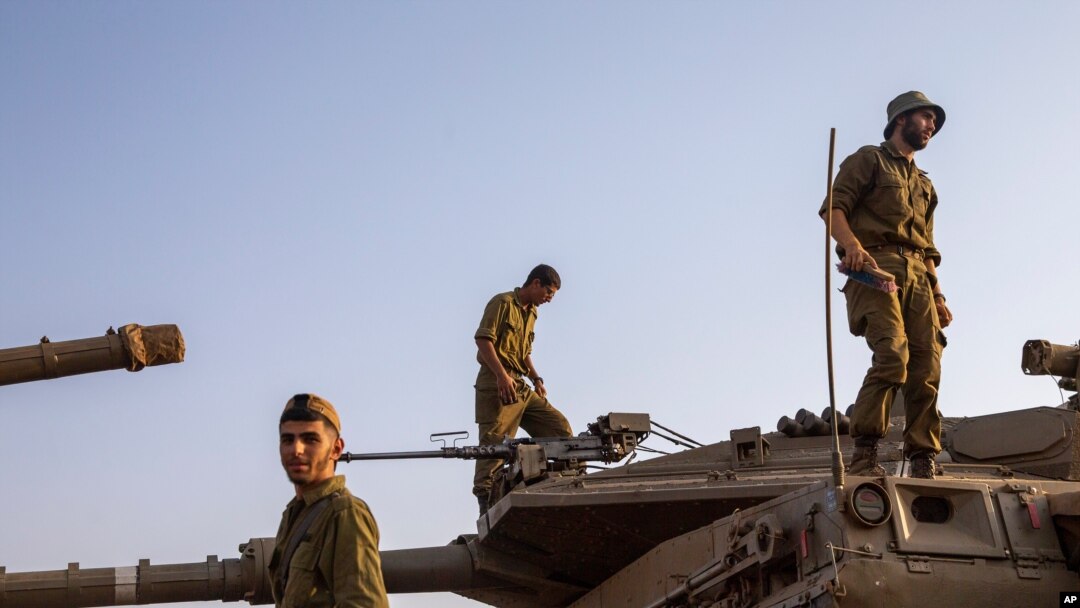 FILE - Israeli soldiers work on tanks in the Israeli controlled Golan Heights near the border with Syria, not far from Lebanon border, July 28, 2020. 