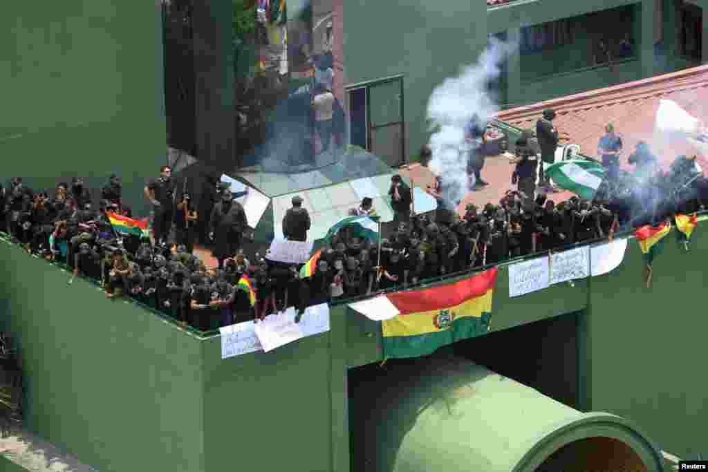 Oficiales de policía se reúnen en una terraza de la sede de la policía con carteles que dicen "motín policial", durante las protestas contra el presidente de Bolivia, Evo Morales, en Santa Cruz de la Sierra, Bolivia, el sábado.