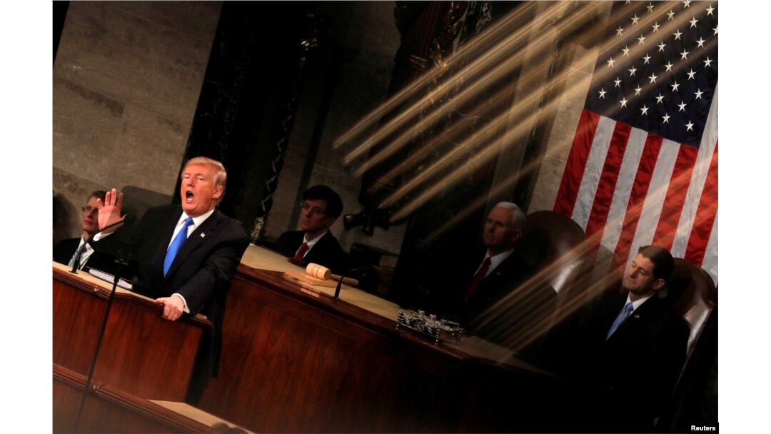 FILE - U.S. President Donald Trump is seen under the reflection of a House chamber railing as he delivers his State of the Union address to a joint session of the U.S. Congress on Capitol Hill in Washington, Jan. 30, 2018.
