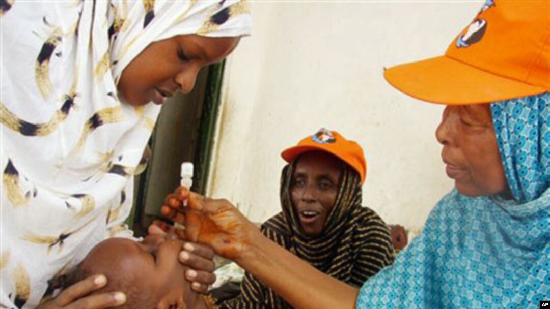Wata jami'a ta Hukumar Kiwon lafiya ta Duniya tana diga ma wani jariri maganin rigakafin cutar Polio a Mogadishu, Somaliya.