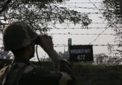 FILE - An Indian Border Security Force (BSF) soldier keeps vigil during patrol along the fenced border with Pakistan in Ranbir Singh Pura sector near Jammu, Feb. 26, 2019.