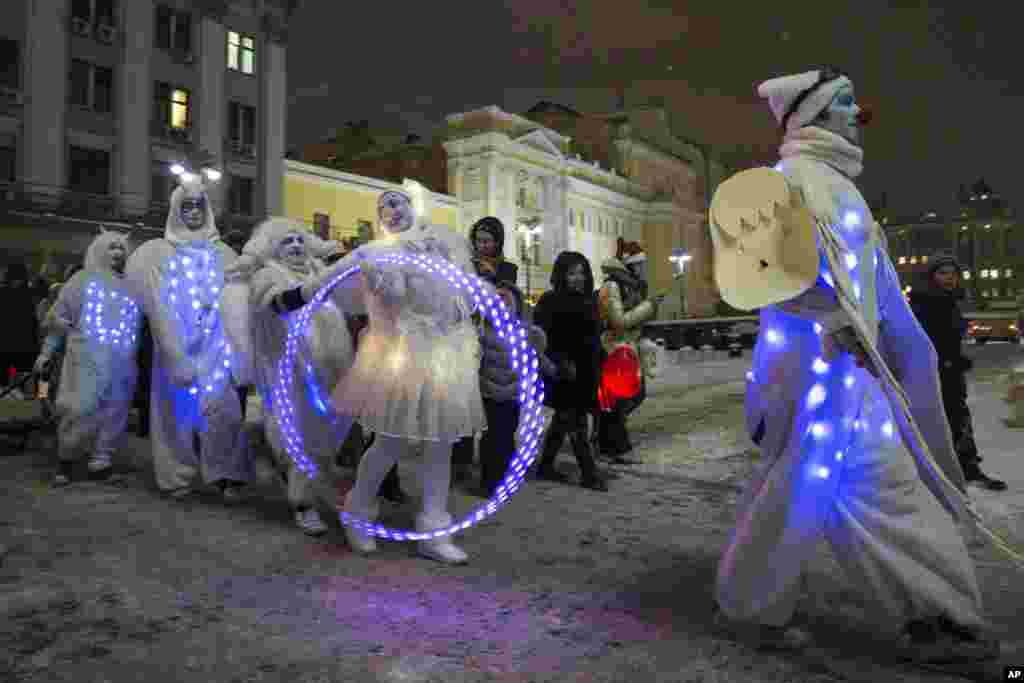 People dressed in illuminated angel costumes parade to mark Christmas Day in central Moscow, Russia, Dec. 25, 2014.