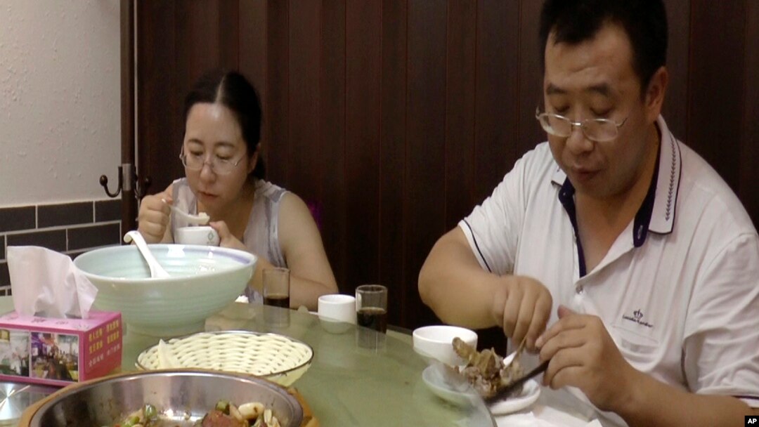 FILE - This image made from Aug. 1, 2016 video shows Chen Guiqiu, left, has lunch with lawyer Jiang Tianyong after attending a trial for human rights lawyer and activists at the Tianjin No. 2 Intermediate People's Court in Tianjin, China.