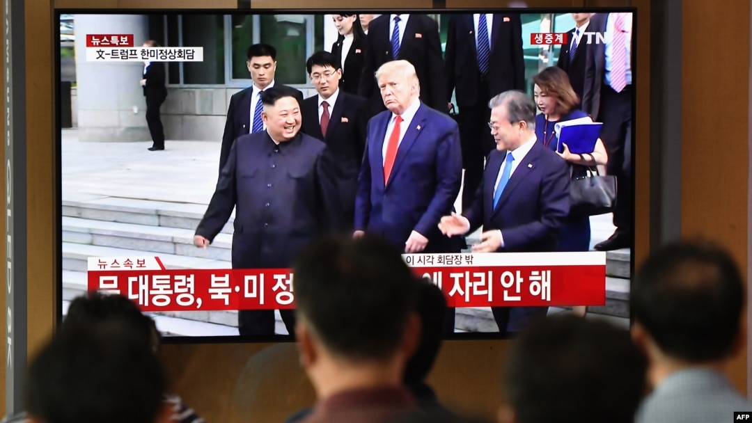 FILE - People watch a television news screen showing U.S. President Donald Trump, South Korean Moon Jae-in and North Korean leader Kim Jong Un meeting at the truce village of Panmunjom in the DMZ, at a railway station in Seoul, June 30, 2019. 