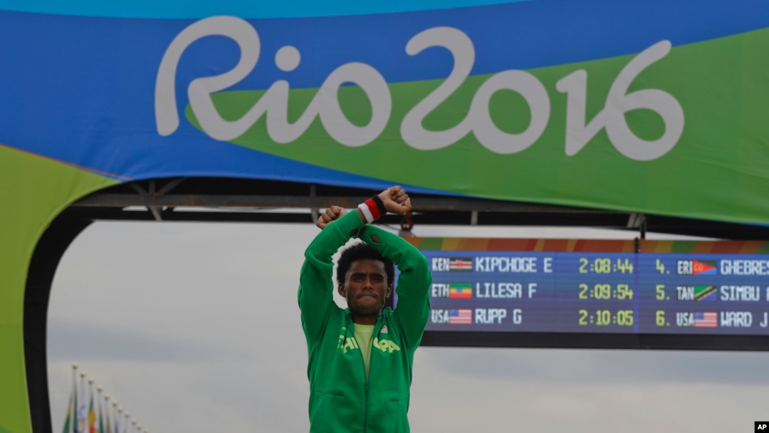 Silver medalist Ethiopia's Feyisa Lilesa, crosses his arms as he celebrates on the podium after the men's marathon at the 2016 Summer Olympics in Rio de Janeiro, Brazil, Sunday, Aug. 21, 2016. 