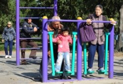资料照：北京天坛公园里的老年人和他们的独生子女的孙辈在锻炼身体。（2011年10月25日）
