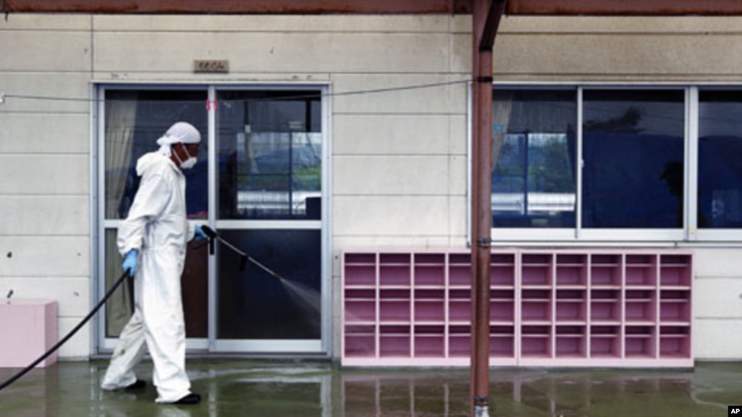 A worker decontaminates radiation from the exterior of Yasawa Kindergarten in Minami-Soma, about 20 kilometers away from the crippled Fukushima Dai-ichi nuclear facility in Fukushima prefecture, northeastern Japan, August 18, 2011.