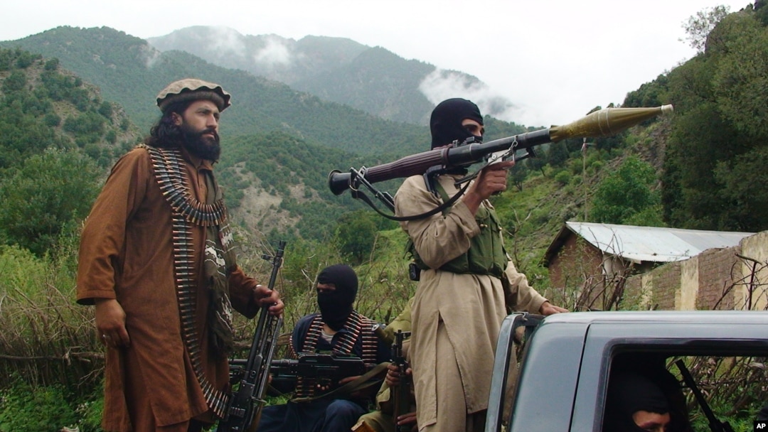 FILE - Pakistani Taliban patrol in their stronghold of Shawal in Pakistani tribal region of South Waziristan, Aug. 5, 2012.