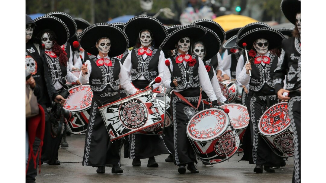 FILE - Performers participate in the Day of the Dead parade in Mexico City.