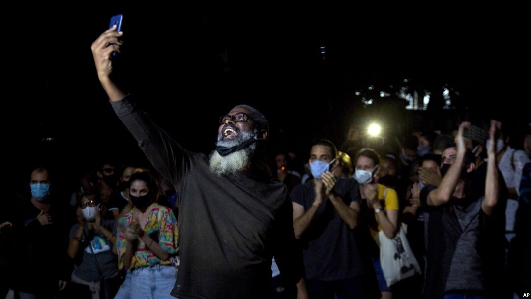 Jóvenes artistas protestan frente a las puertas del Ministerio de Cultura, en La Habana, Cuba, el viernes 27 de noviembre de 2020. Decenas de artistas cubanos protestaron contra la policía que desalojó a un grupo que participaba en una huelga de hambre.