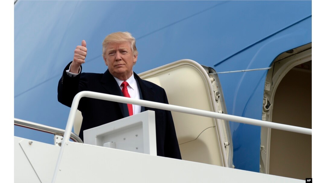 President Donald Trump gives a thumbs up from the top of the steps of Air Force One at Andrews Air Force Base in Maryland, Feb. 17, 2017.